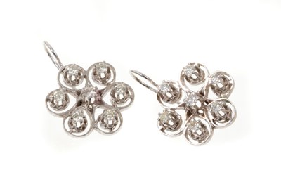 Lot 501 - Pair of diamond flower head cluster earrings, each with seven brilliant cut diamonds in 14k white gold setting