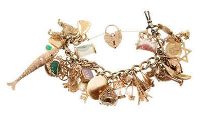 Lot 621 - Gold charm bracelet with an extensive collection of 9ct gold charms.