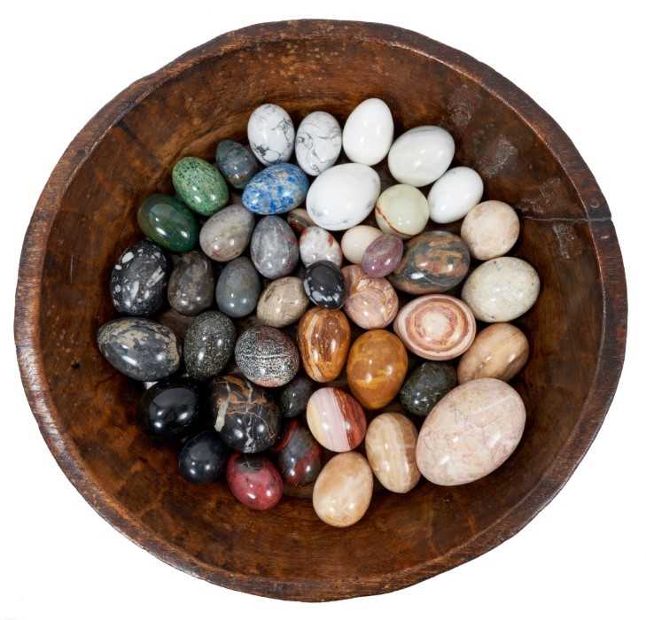 Lot 817 - Collection of forty-five specimen stone eggs, in antique treen bowl