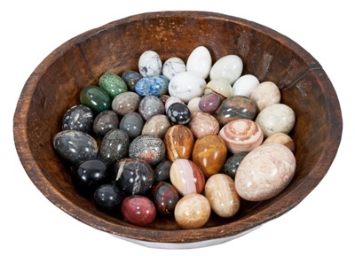 Lot 817 - Collection of forty-five specimen stone eggs, in antique treen bowl