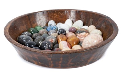 Lot 817 - Collection of forty-five specimen stone eggs, in antique treen bowl