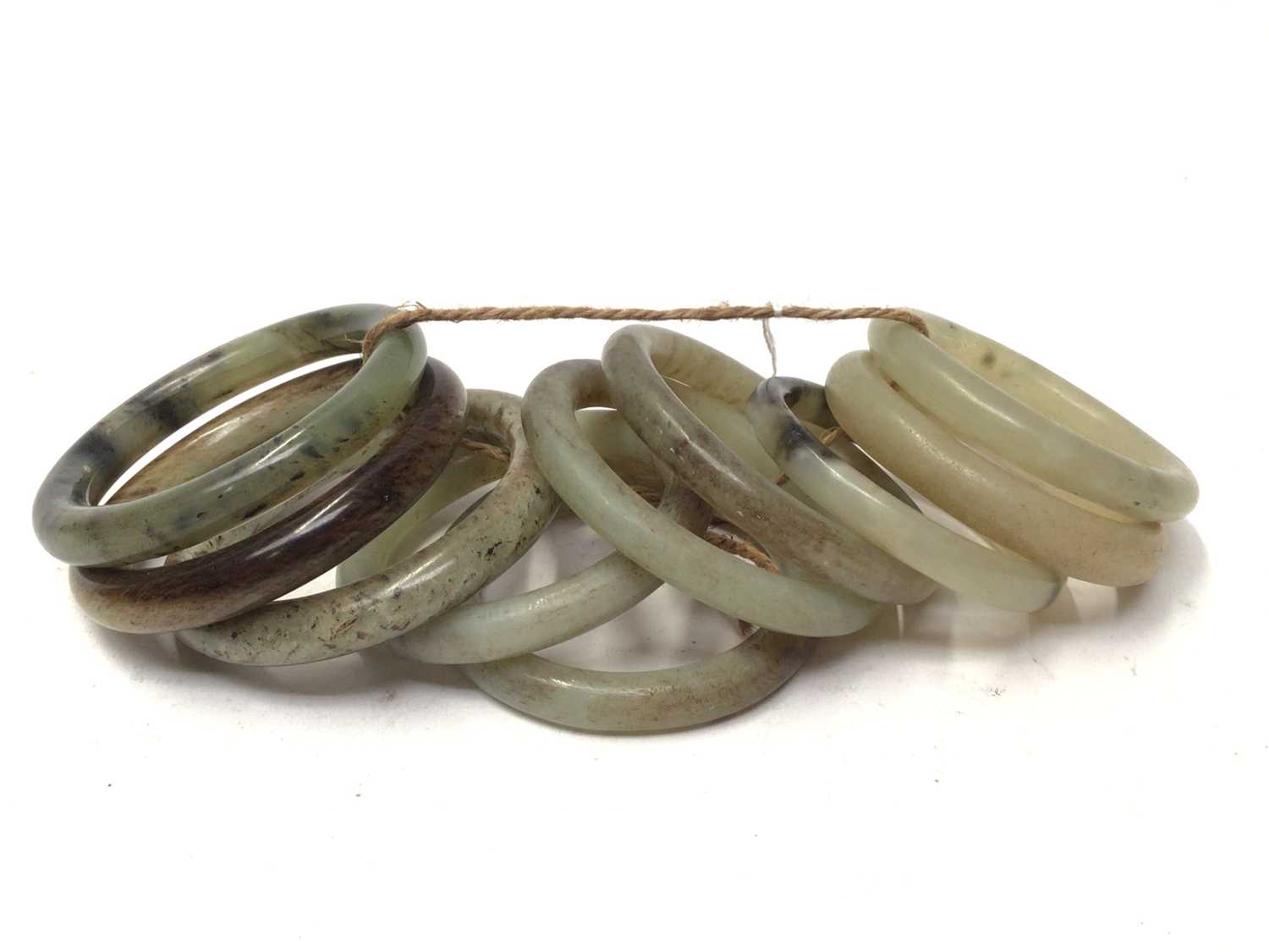 Lot 37 - Ten green jade/ hard stone polished bangles