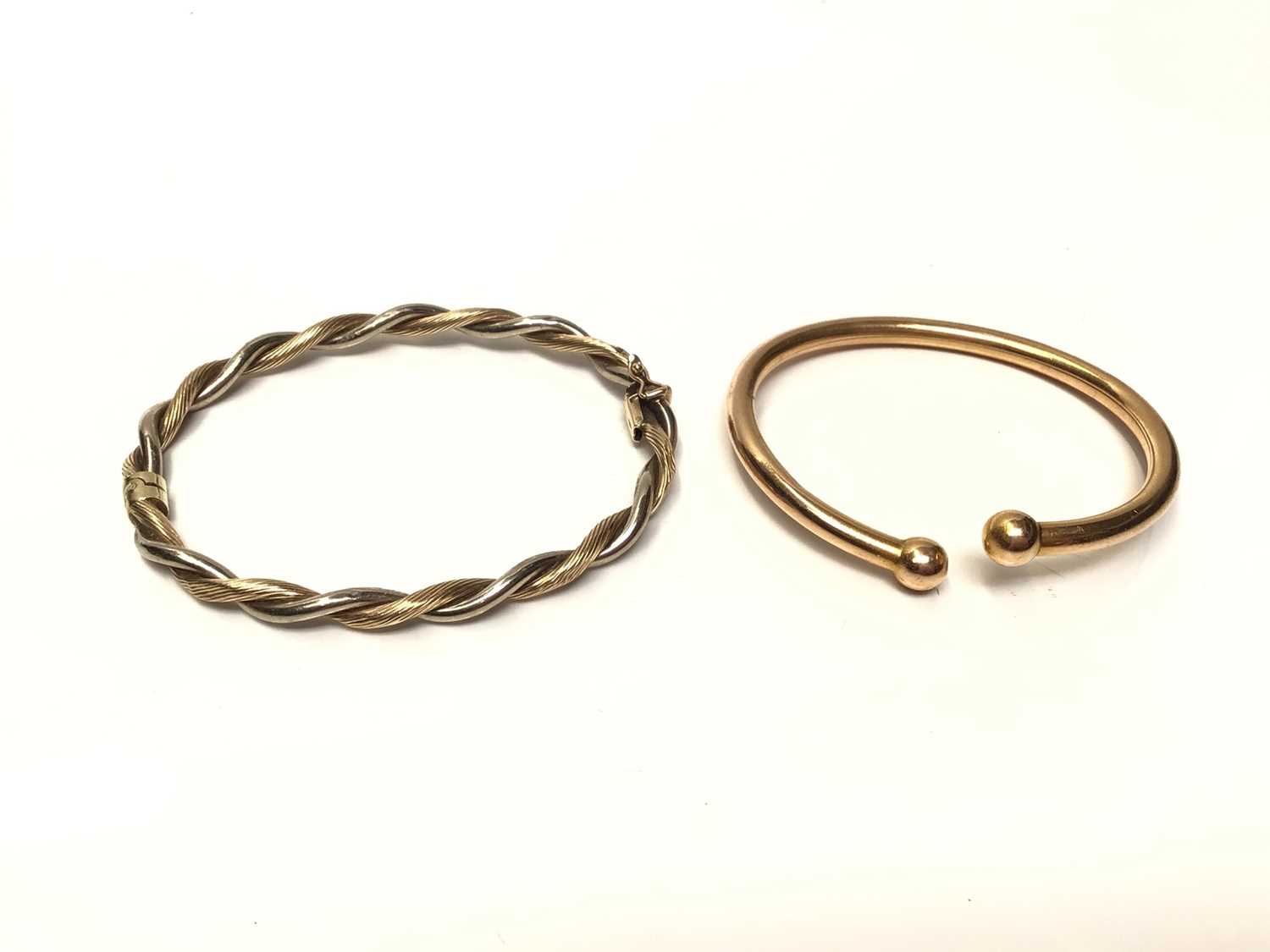 Lot 65 - 9ct yellow and white gold twisted bangle and one other yellow metal torque bangle