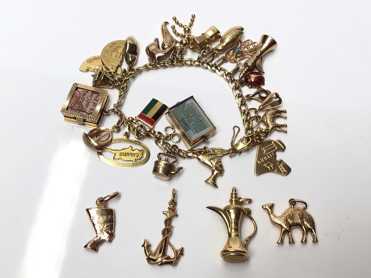Lot 76  18ct gold charm bracelet with various 18ct