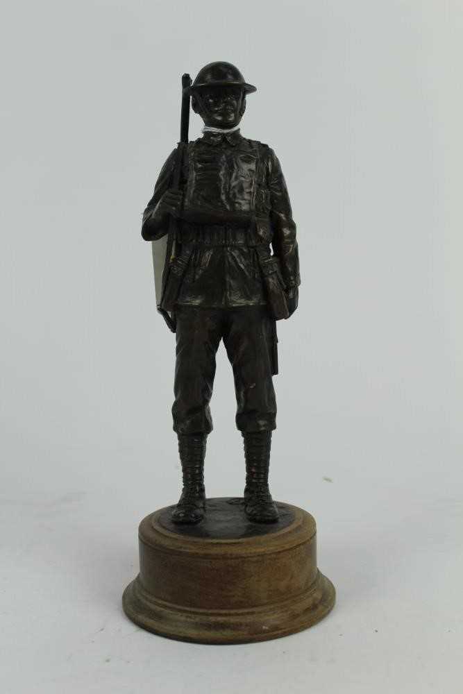 Lot 770 - Contemporary bronzed resin figure of a First World War Tommy, mounted on circular wooden base, 24cm in overall height.