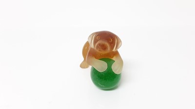 Lot 1031 - Daum Pate de Verre amber glass model of a dog with green glass ball, signed, 5.5cm high