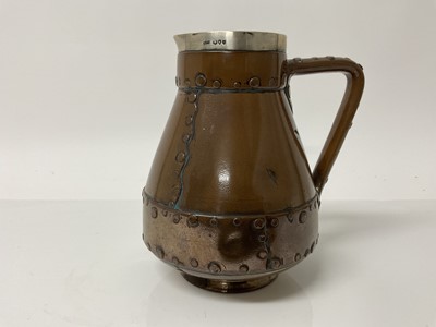 Lot 1082 - Doulton Lambeth Silicon ware jug, made to resemble a copper riveted jack, with silver rim, impressed marks to base, 18.5cm high