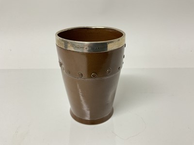 Lot 1083 - Doulton Silicon beaker in the form of a leather studded cup with silver rim, impressed marks to base, 11cm high