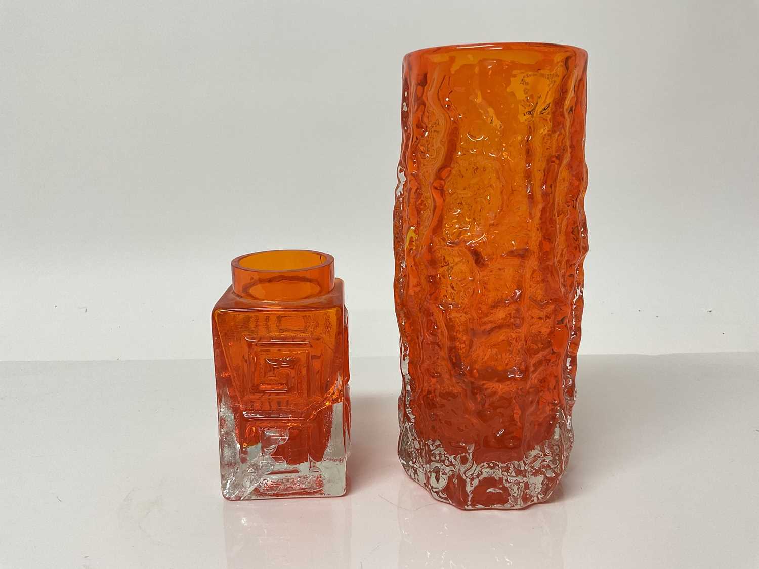 Lot 1101 - Whitefriars Tangerine textured bark vase designed by Geoffrey Baxter, 19.5cm high together with a damaged Greek key vase (2)