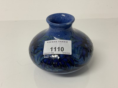 Lot 1110 - Moorcroft pottery squat vase decorated with foliage on powder blue ground, impressed marks and blue painted signature to base, 8.5cm high