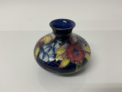 Lot 1111 - Moorcroft pottery squat vase with floral decoration on blue ground, impressed marks to base, 8.5cm high