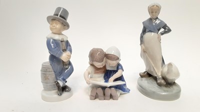 Lot 1183 - Three Royal Copenhagen figures - boy with top hat, numbered 4524, boy and girl reading, numbered 1567 and lady with goose, numbered 528