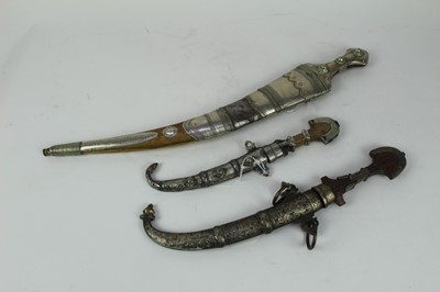 Lot 872 - Arab Jambiya dagger with silver and brass mounted scabbard and grip, together with two other Eastern daggers (3)