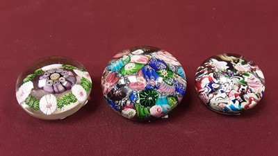 Lot 1092 - Two 19th century scrambled glass paperweights, together with a another cane paperweight (3)