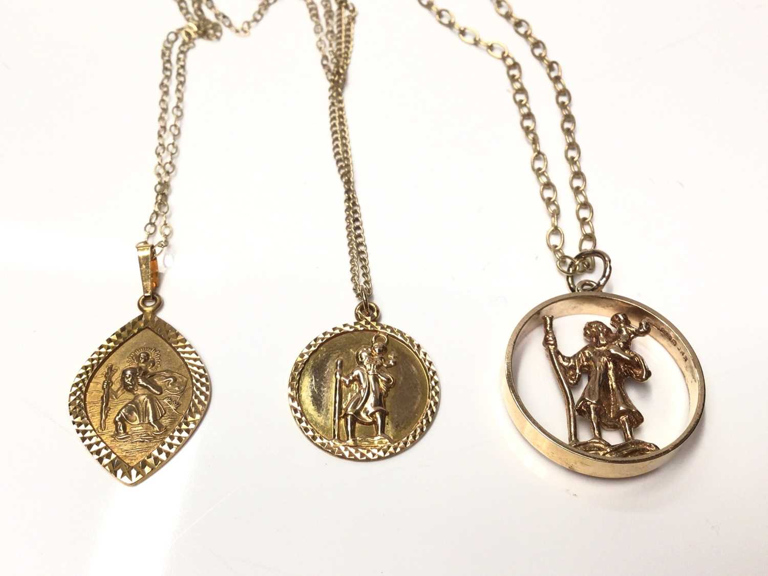Lot 179 - Three 9ct gold St. Christopher pendants on 9ct gold chains