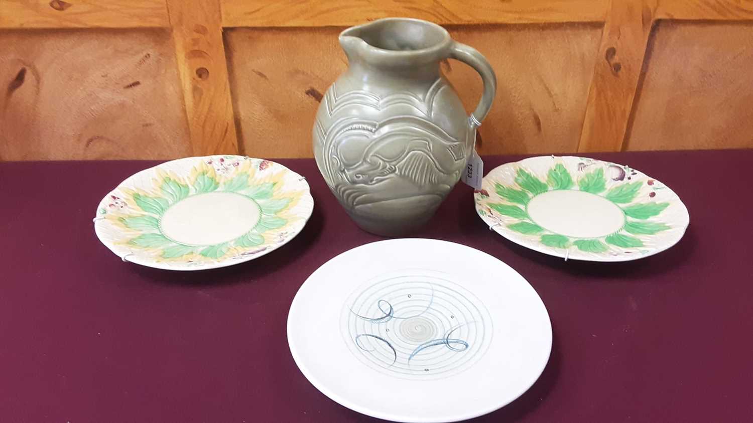 Lot 520 - Susie Cooper 'Leaping Deer' pattern jug, 21cm high, together with a Susie Cooper plate and two Clarice Cliff plates (4)