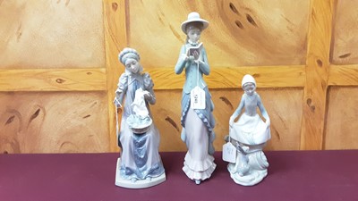 Lot 1240 - Three Lladro porcelain figures - lady reading, lady sewing and lady with rabbit, all boxed