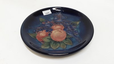 Lot 1244 - Moorcroft pottery plate decorated in the fruit and finch pattern on blue ground, impressed marks and painted WM, 26cm diameter