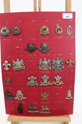 Lot 842 - Four boards mounted with British military cap badges, various regiments including Suffolk Regiment, and Royal Warwickshire Regiment, some reproductions noted (approximately 103 badges)