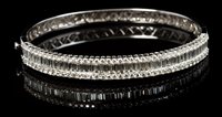 Lot 792 - Diamond hinged bangle with a row of baguette...