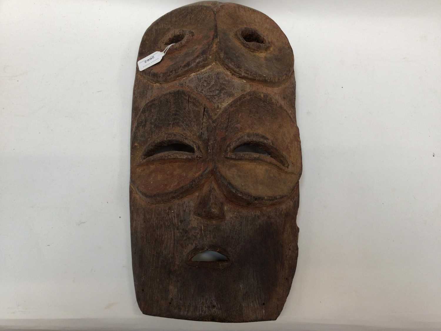 Lot 2662 - Large African wooden mask with four eyes, traces of polychrome, together with a smaller female African mask (2)