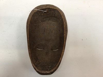 Lot 2662 - Large African wooden mask with four eyes, traces of polychrome, together with a smaller female African mask (2)