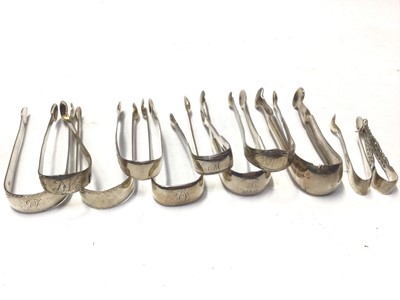 Lot 327 - Eleven pairs of Georgian and Victorian silver sugar tongs, most with bright cut engraved decoration, various dates and makers, all at approximately 10oz, (11)