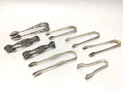 Lot 333 - Eight pairs of George III, filigree and other silver sugar tongs, various dates and makers, all at approximately 6oz, (8)