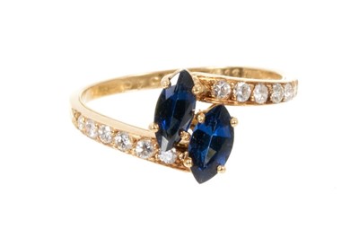 Lot 526 - Cartier sapphire and diamond cross-over ring with two marquise cut blue sapphires in a cross-over design with graduated brilliant cut diamonds to the shoulders on 18ct yellow gold shank, signed Car...