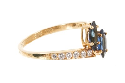 Lot 526 - Cartier sapphire and diamond cross-over ring with two marquise cut blue sapphires in a cross-over design with graduated brilliant cut diamonds to the shoulders on 18ct yellow gold shank, signed Car...