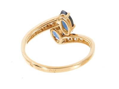 Lot 526 - Cartier sapphire and diamond cross-over ring with two marquise cut blue sapphires in a cross-over design with graduated brilliant cut diamonds to the shoulders on 18ct yellow gold shank, signed Car...