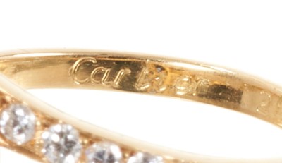 Lot 526 - Cartier sapphire and diamond cross-over ring with two marquise cut blue sapphires in a cross-over design with graduated brilliant cut diamonds to the shoulders on 18ct yellow gold shank, signed Car...