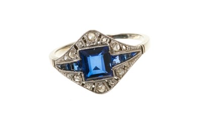 Lot 577 - Art Deco sapphire and diamond ring with a central step cut blue sapphire flanked by tapered calibre cut blue sapphires and rose cut diamonds in pierced platinum millegrain setting. French control m...