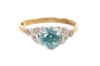 Lot 531 - Blue zircon and diamond ring with a round mixed cut blue zircon measuring approximately 6.7mm in platinum claw setting with diamond shoulders on 18ct yellow gold shank, ring size L½.