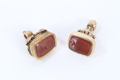 Lot 535 - Two Georgian yellow metal seals with carnelian intaglios, largest 27mm.