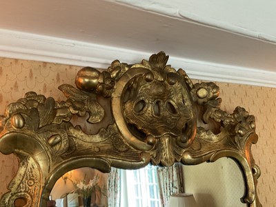 Lot 1238 - Early 18th century style pierced gilt gesso wall mirror, shaped plate within pieced c-scroll frame with foliate swags, 109 x 56cm