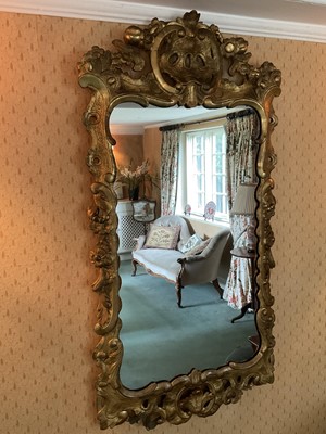 Lot 1238 - Early 18th century style pierced gilt gesso wall mirror, shaped plate within pieced c-scroll frame with foliate swags, 109 x 56cm