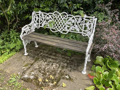 Lot 1277 - White painted cast iron bench, with lattice, vine and bird ornament