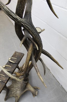 Lot 1310 - Antique Tyrolean hunting lodge worked antler gun stand, with three housings, on spread base, 134cm high