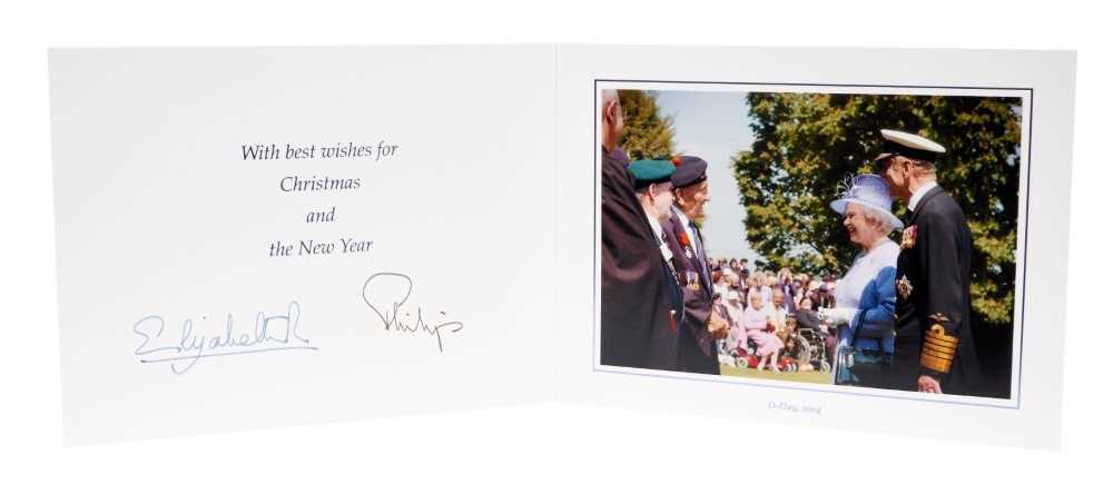 Lot 85 - H.M.Queen Elizabeth II and H.R.H. The Duke of Edinburgh, signed 2004 Christmas card with twin gilt Royal ciphers to cover and colour photograph of the Queen and Prince Philip talking to D-Day veter...