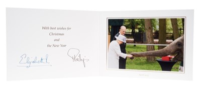Lot 97 - H.M.Queen Elizabeth II and H.R.H. The Duke of Edinburgh, signed 2017 Christmas card with twin gilt Royal ciphers to cover and colour photograph of the Royal Couple feeding an elephant to the interi...
