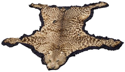 Lot 906 - Early 20th century leopard skin rug with full head mount on black felt backing