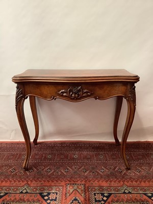 Lot 1446 - Victorian figured walnut veneered card table with serpentine front, carved floral frieze on cabriole legs, 86cm wide.