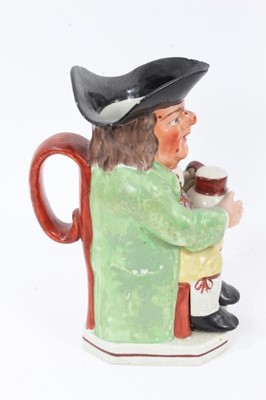 Lot 291 - Early 19th century Staffordshire Pearlware Toby jug, in green jacket and brightly coloured waistcoat, with spotty red face, 24cm high