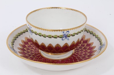 Lot 20 - A Chelsea-Derby tea bowl and saucer, circa 1770, pineapple-moulded and painted with floral sprays and foliate patterns, on a red ground, gold anchor marks, the saucer measuring 12.75cm diameter