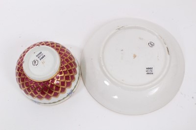 Lot 20 - A Chelsea-Derby tea bowl and saucer, circa 1770, pineapple-moulded and painted with floral sprays and foliate patterns, on a red ground, gold anchor marks, the saucer measuring 12.75cm diameter