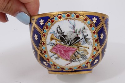 Lot 29 - A Sèvres porcelain bowl, 1758-9, painted with a scene of two soldiers playing cards, inside a circular panel with jewelled border, on a blue ground with moulded fleur-de-lys pattern, a panel to rev...