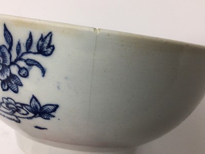 Lot 52 - A rare Isleworth blue and white porcelain bowl, circa 1770, transfer printed with a variation of the Fence pattern on one side, and another Oriental scene verso, with a cornucopia, two birds and a...