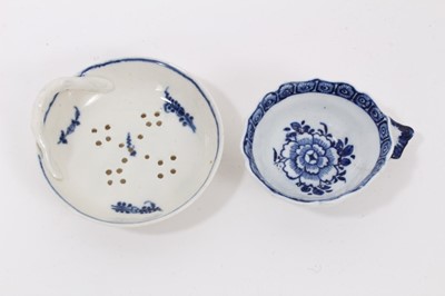 Lot 55 - A Derby blue and white wine taster, circa 1770, decorated with a central flower and floral border, together with a blue and white egg strainer, also possibly Derby (2)