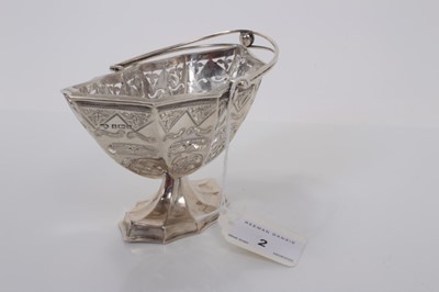 Lot 2 - Edwardian silver sugar basket of navette form with pierced and engraved decoration, swing handle and clear glass liner, raised on pedestal foot, (Birmingham 1901), maker William Aitken, 15cm wide,...